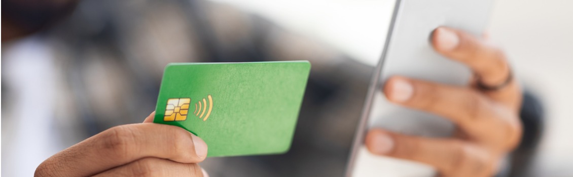 person holding a Debit card  with a phone. 