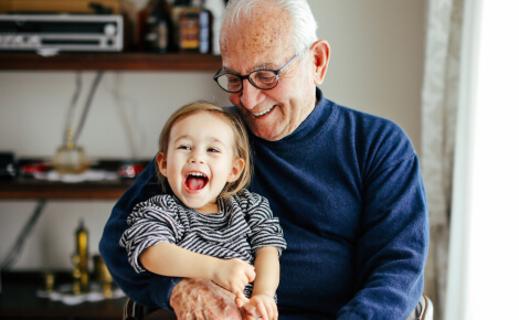 Mature man holding a happy toddler