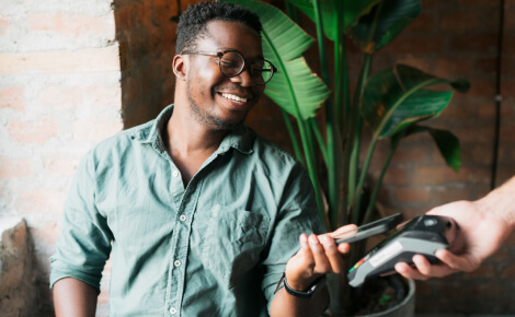 Young man paying with his smartphone