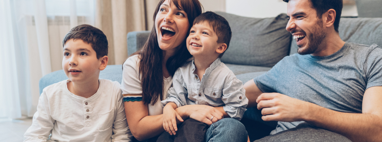 Happy family of four in living room