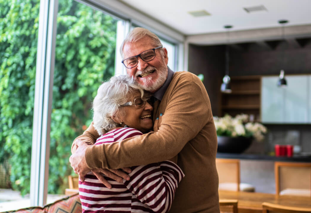 Mature couple embracing in a living room