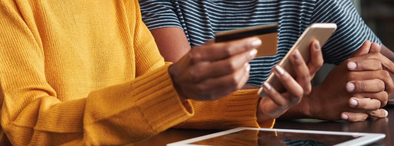 Woman holding credit/debit card and a mobile phone