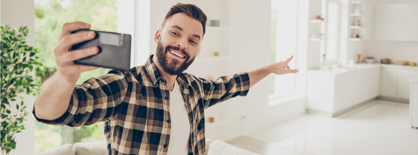 Young man taking a selfie in his kitchen. 